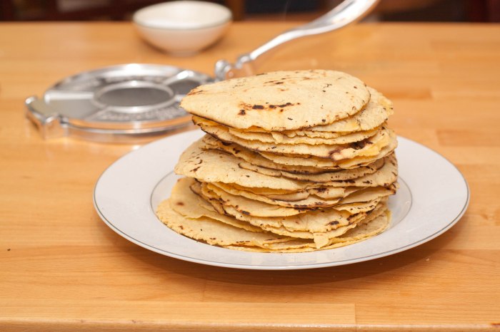fresh made homemade corn tortillas stacked high on a plate